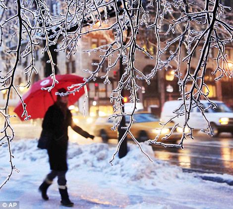 A woman makes her way along an icy pavement in New York, the colossal blizzard has roared across a third of the country