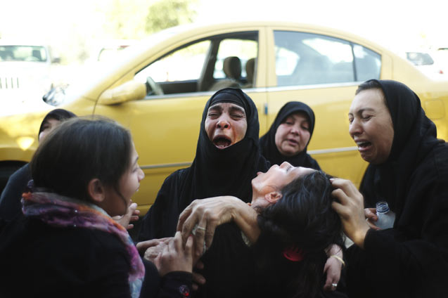 Family members grieve for a Sunni relative allegedly executed by members of a Shiite militia outside their home in Baghdad, June 25, 2014. (Photo: Ayman Oghanna / The New York Times)