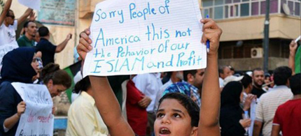 Young Egyptian holds sign apologizing for the Benghazi attack. (photo: Reuters)