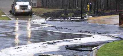 Men wearing protective clothing survey cleanup efforts where an underground crude oil pipeline ruptured in Mayflower, Arkansas, 03/30/13. (photo: Reuters)