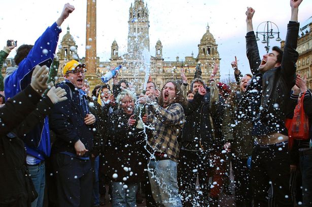 Revellers spray a bottle of champagne as they celebrate the death of former British prime minister Margaret Thatcher, at George Square in Glasgow