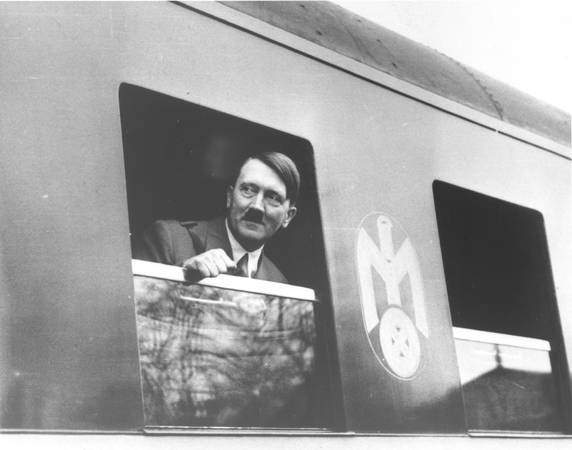 Picture of Adolf Hitler looking out the window of a train.
