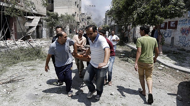 Run for LIves: Desperate Palestinians carry body from streets of Gazas Shejaia neighborhood after fierce shelling kills dozens of civilians.