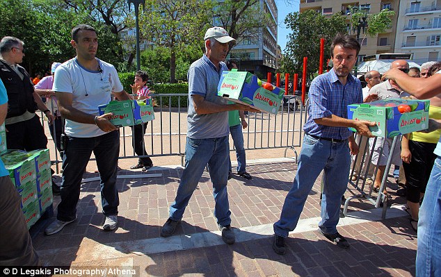 Help: Volunteers hand out boxes of fresh fruit and vegetables donated to hungry Greeks in Athens by farmers from Crete 