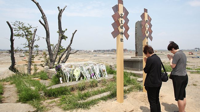 People pray at a shrine for victims