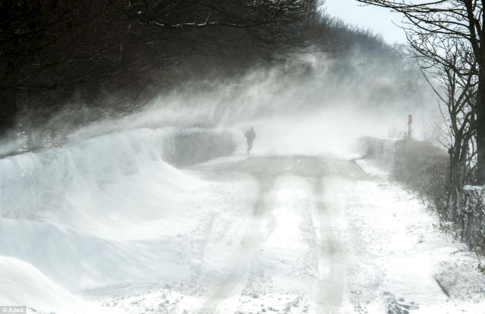 Swirling snow: The snow is whipped up by the swirling winds in and around the village of Anderton, near Chorley, Lancashire