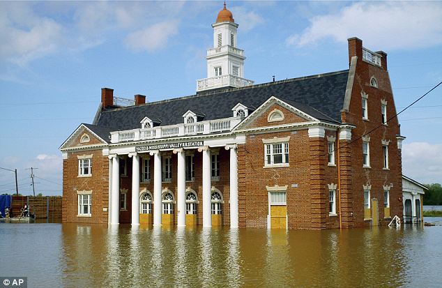 Drenched: Street signs are slowly swallowed by floodwater in Vicksburg, Mississippi yesterday.